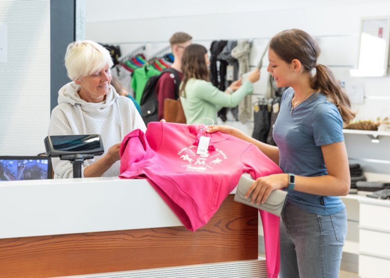 Treffpunkt Marbach mit Gestütsshop- Mitarbeiterin berät Kundin am Tresen 