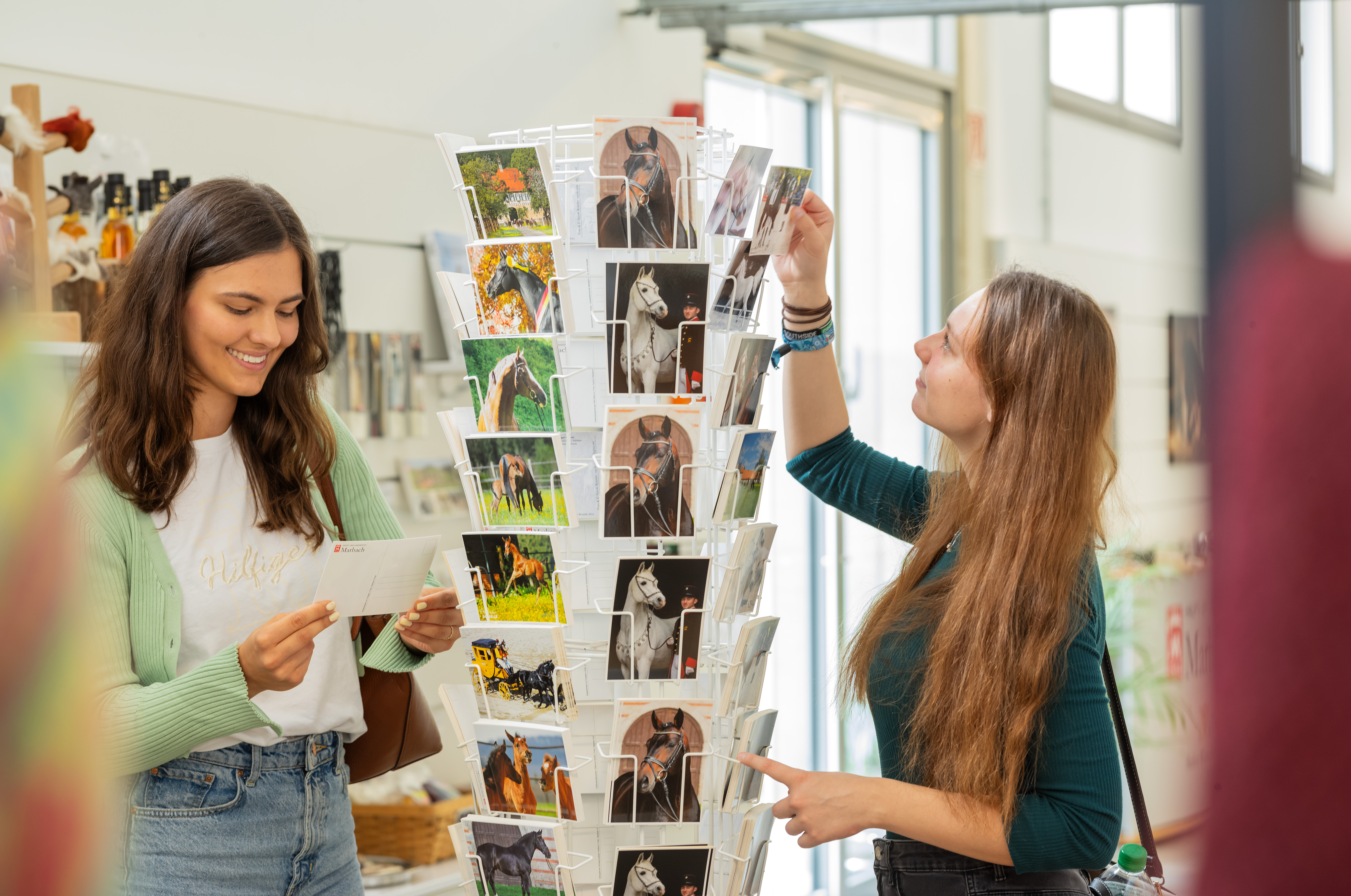 Zwei Frauen suchen Postkarten aus mit Marbachmotiv