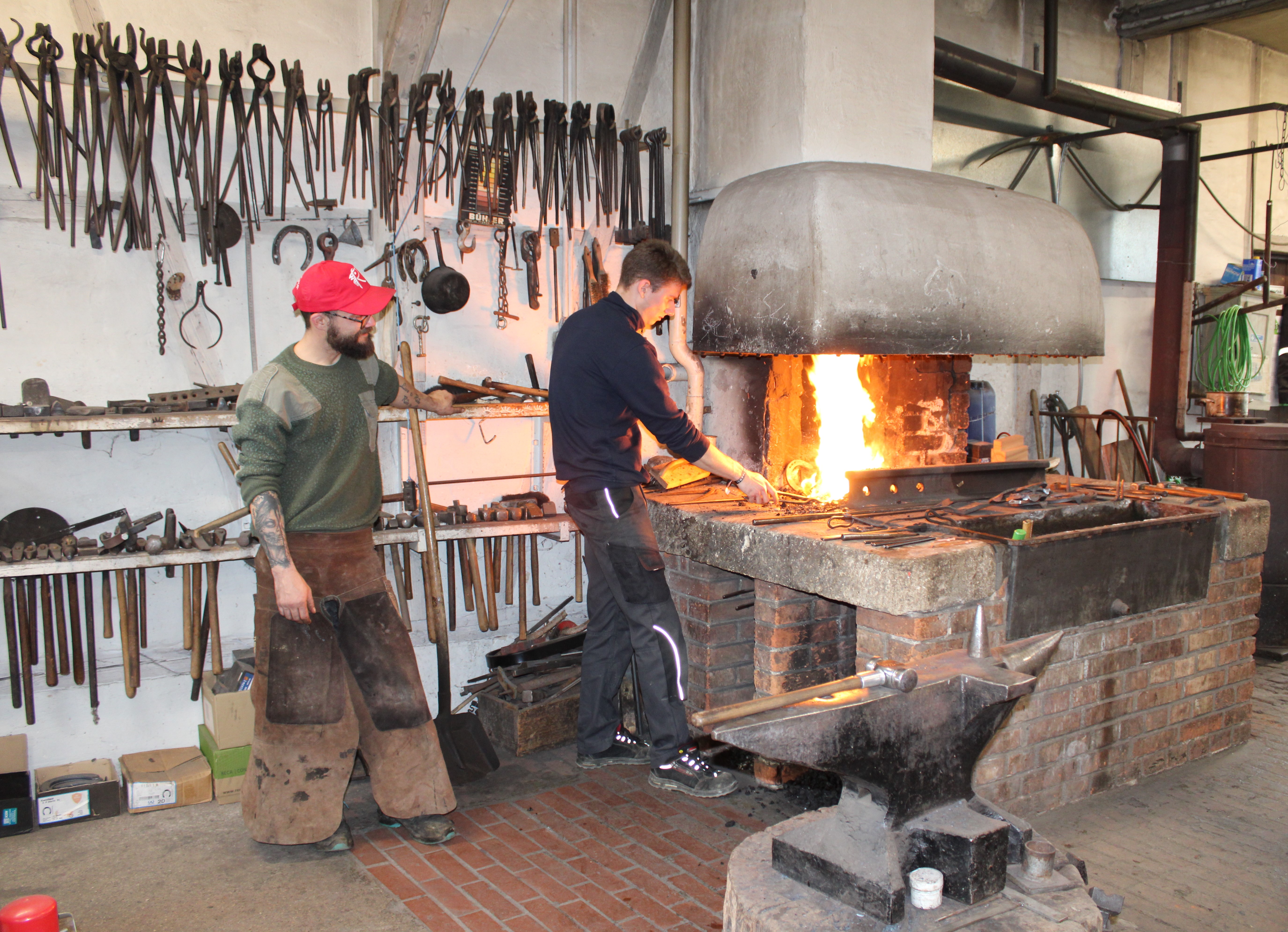 Bild der Esse - zwei Schmiede arbeiten am offenen Feuer 